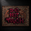 DO NOT TOUCH hand-sprayed graffiti carpet by SeventySeven.DC — magenta spray lettering over a navy and rust Persian medallion weave, 150x200 cm, edition of 5